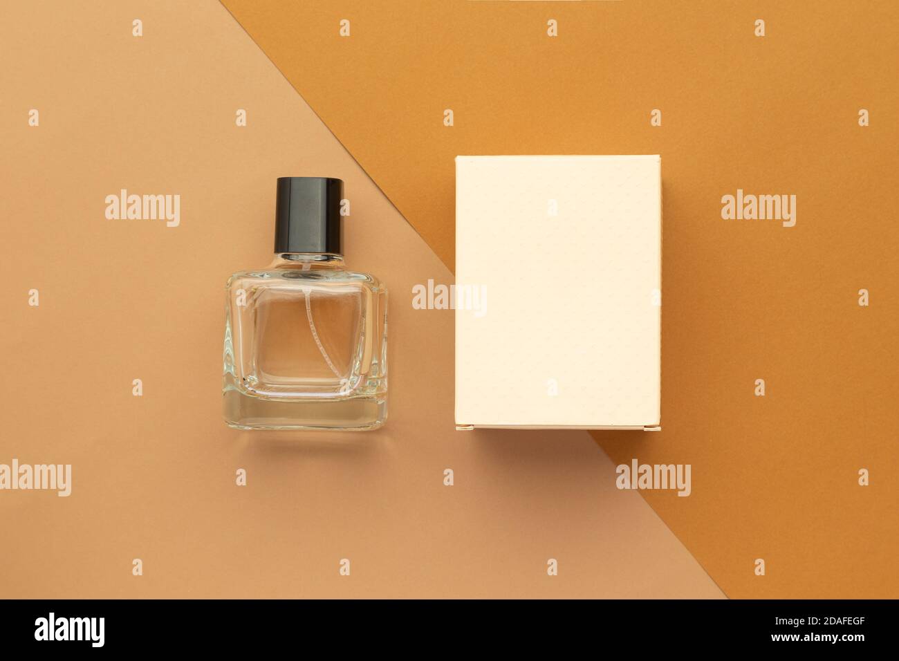 Perfume bottle and box mockup template on beige background. Stock Photo