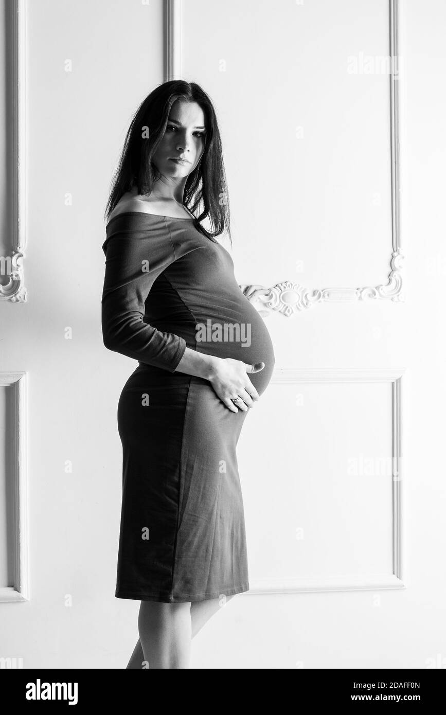 Pregnant girl in a green dress. In late pregnancy. Stock Photo