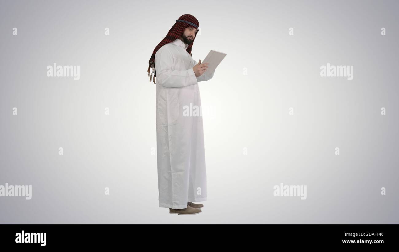 Arabic business man with tablet on gradient background. Stock Photo