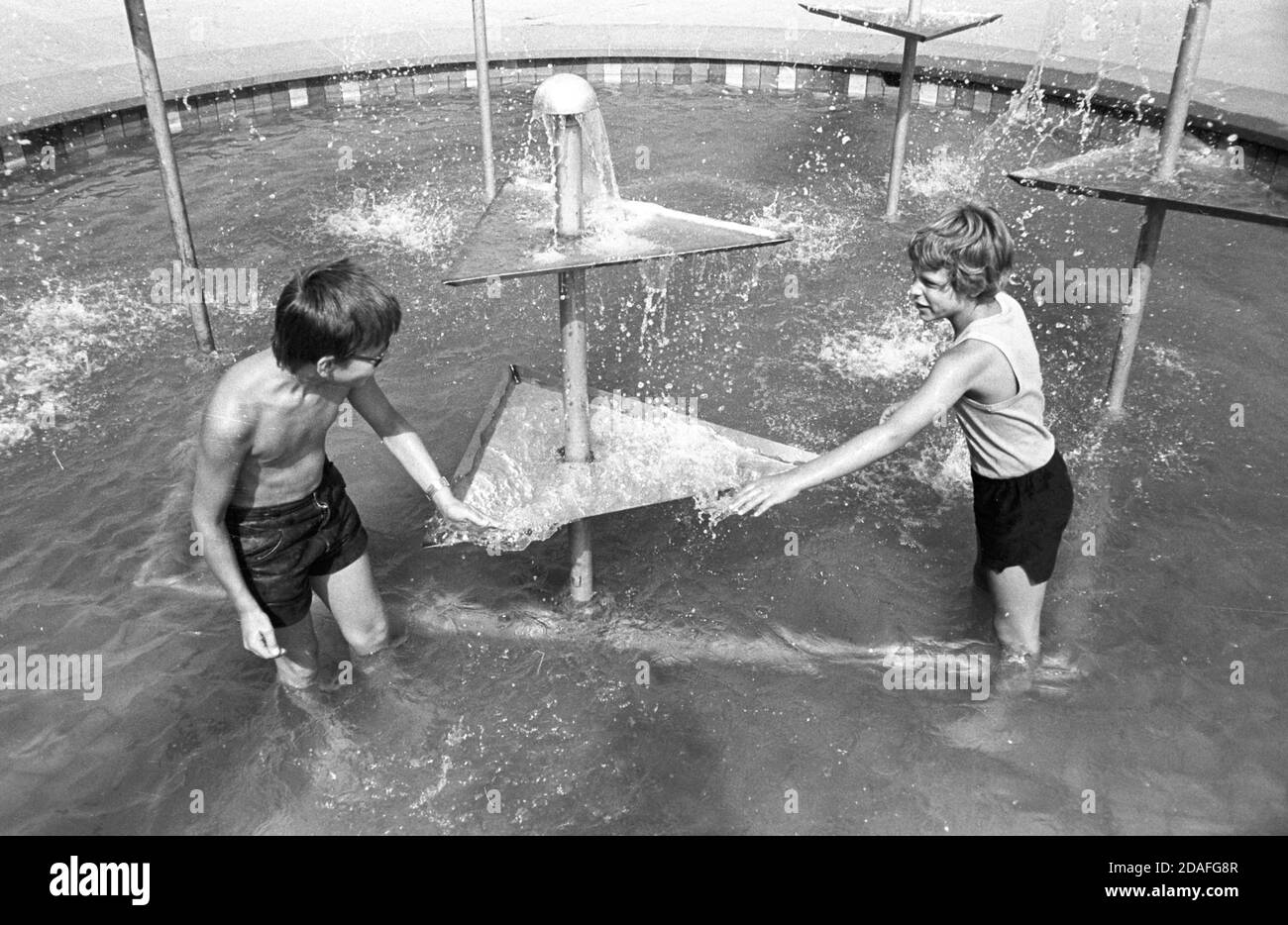 30 August 1984, Saxony, Eilenburg: Children refresh themselves in the summer of 1984 in the market fountain of Eilenburg. Exact date of recording not known. Photo: Volkmar Heinz/dpa-Zentralbild/ZB Stock Photo