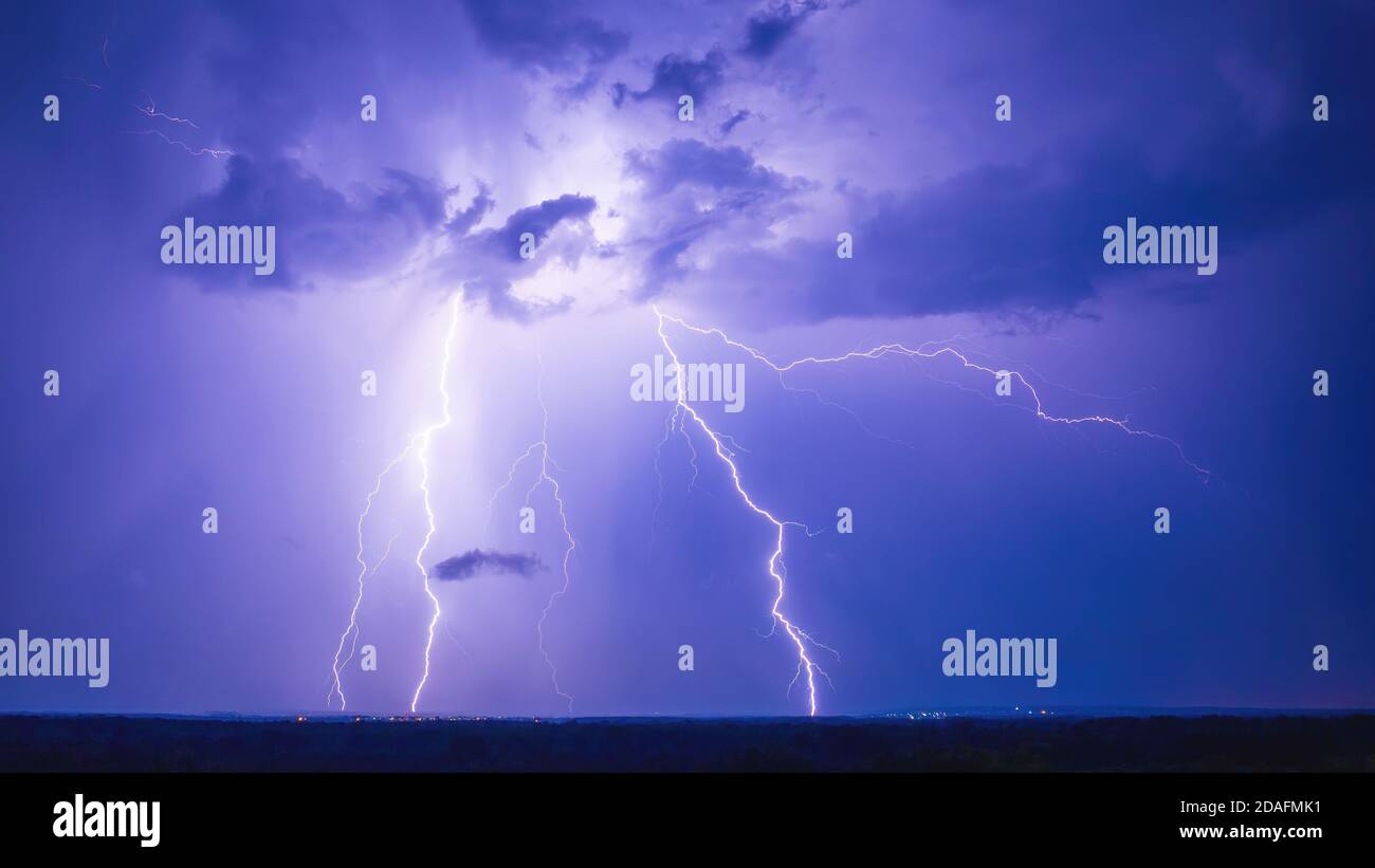 Strokes of cloud-to-ground lightning during grandiose night thunderstorm Stock Photo