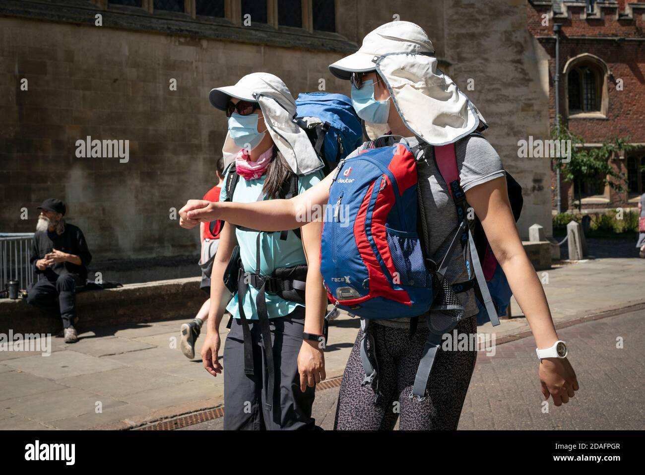 Two tourists dressed in Legionairre's hats and face masks, walk through Cambridge city centre during the 2020 COVID 19 pandemic Stock Photo