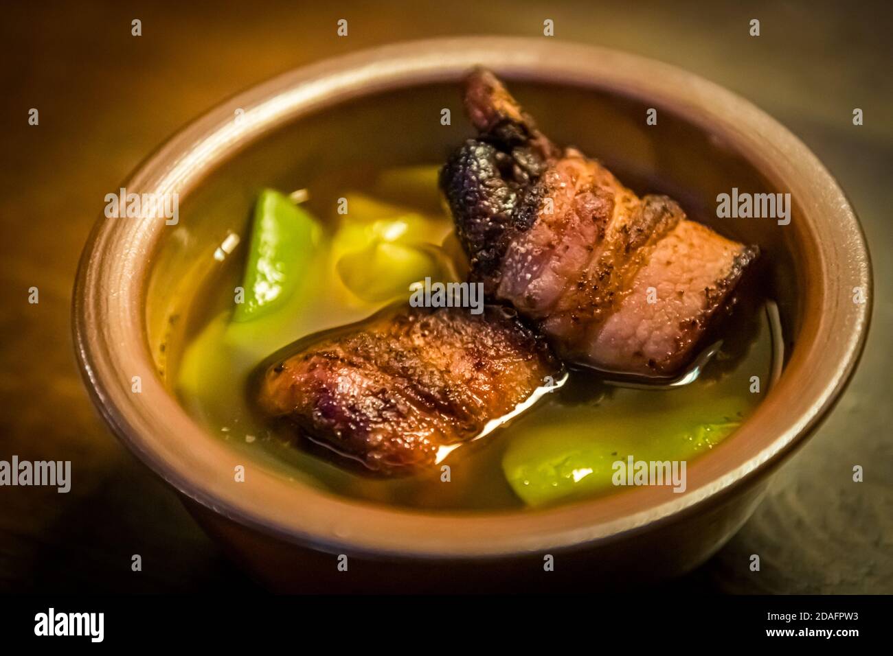 Beansoup at Schlenkerla in real earthenware. As a smoky-sweet component there are bacon figs in addition. Bamberg, Germany Stock Photo