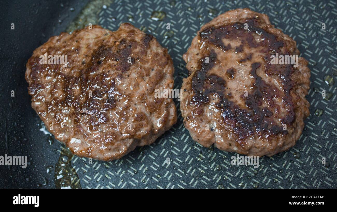 The chef puts beef patties into a frying pan. Juicy beef cutlet is