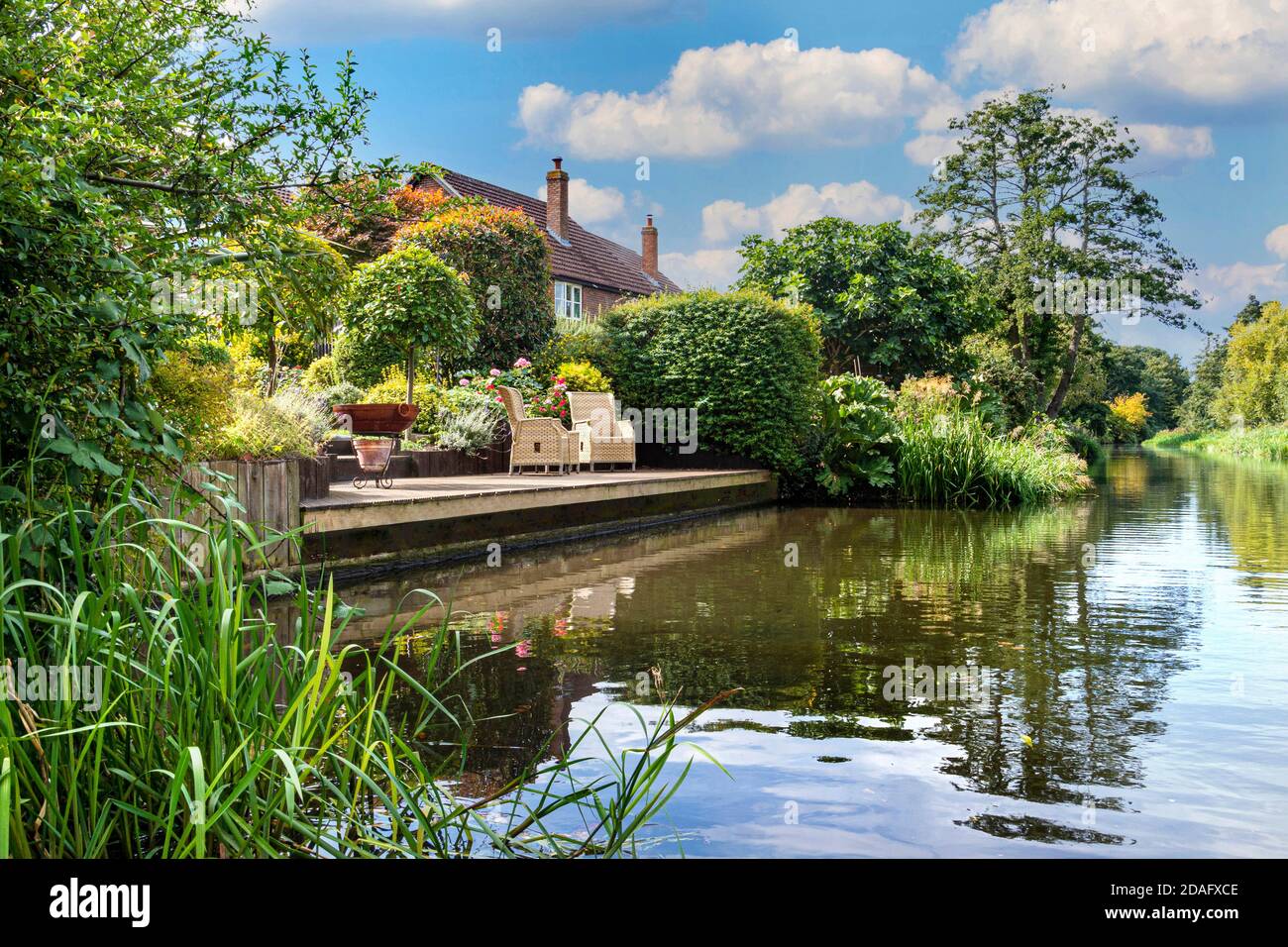 Riverside view home living, staycation, lifestyle, home & garden by the river, tranquil riverside riparian life on The River Wey Surrey UK Stock Photo