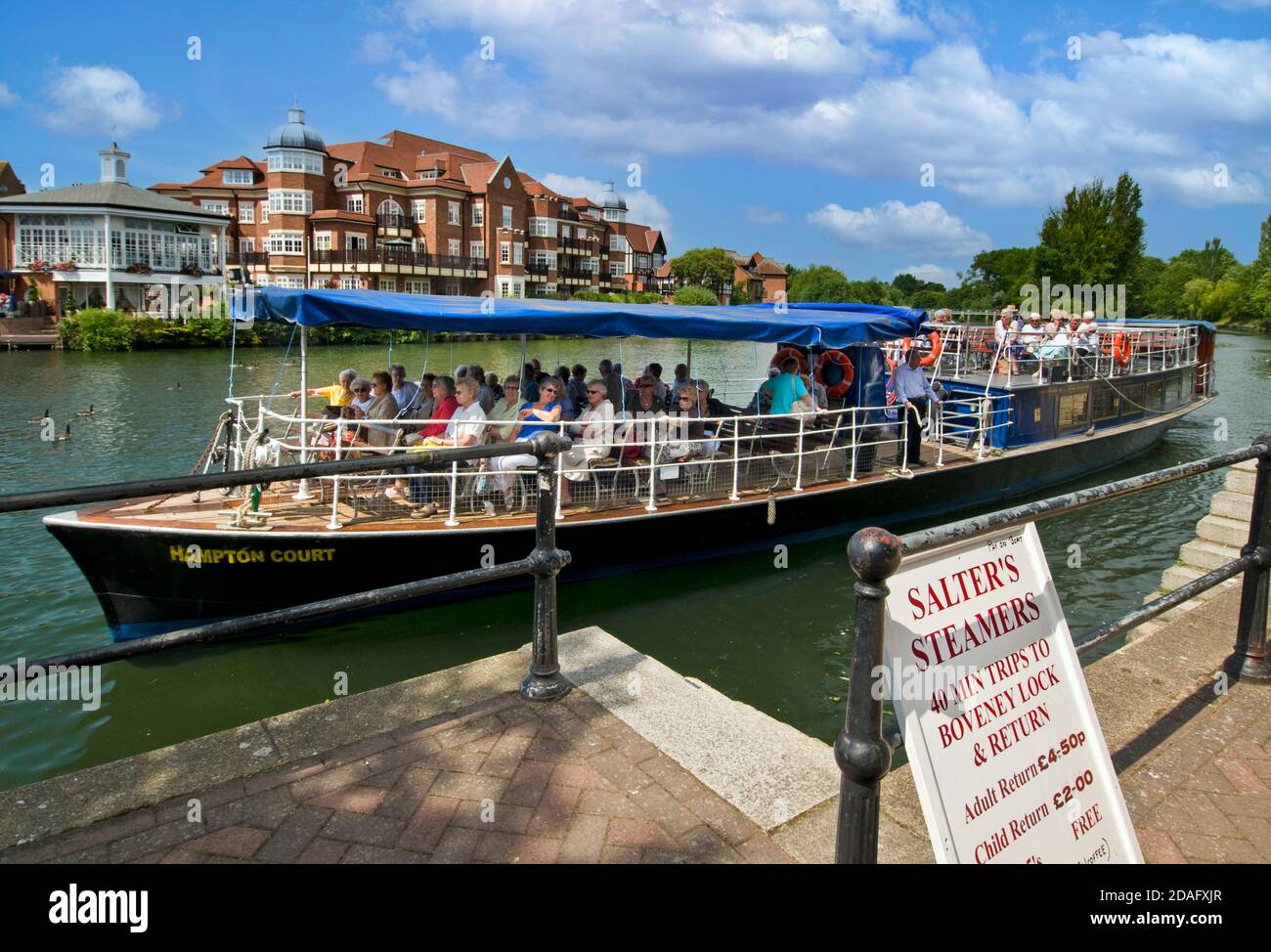 Windsor boat cruise Staycation trip River Thames boat and passengers leaving the mooring at Windsor Berkshire village of Eaton behind Berkshire UK Stock Photo