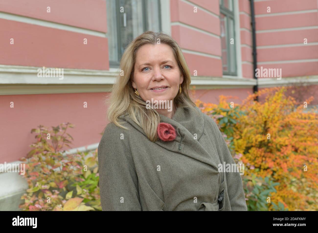 woman with intense blue eyes with a grey coat outdoor in an urban and ...