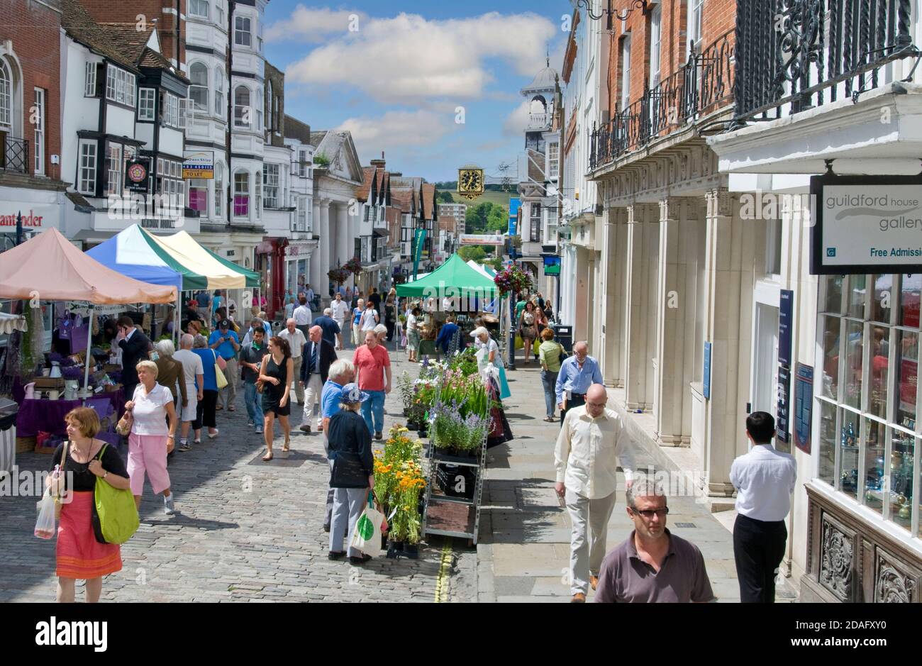 GUILDFORD FARMERS MARKET ALFRESCO FOOD STALLS Guildford historic High Street shops & shoppers on a busy summer farmers market day Guildford Surrey UK Stock Photo