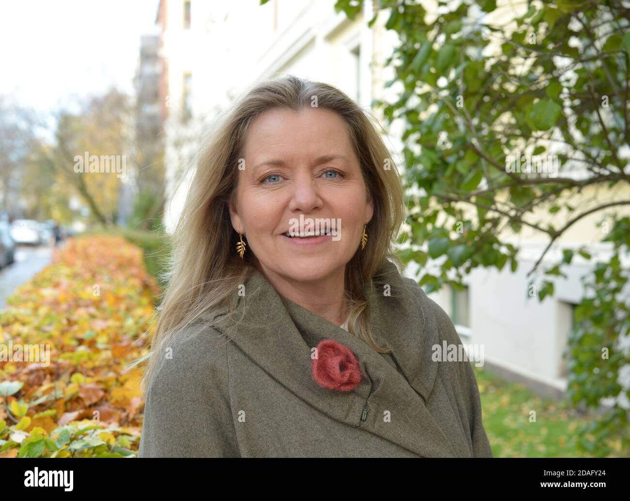 woman with intense blue eyes with a grey coat outdoor in an urban and ...