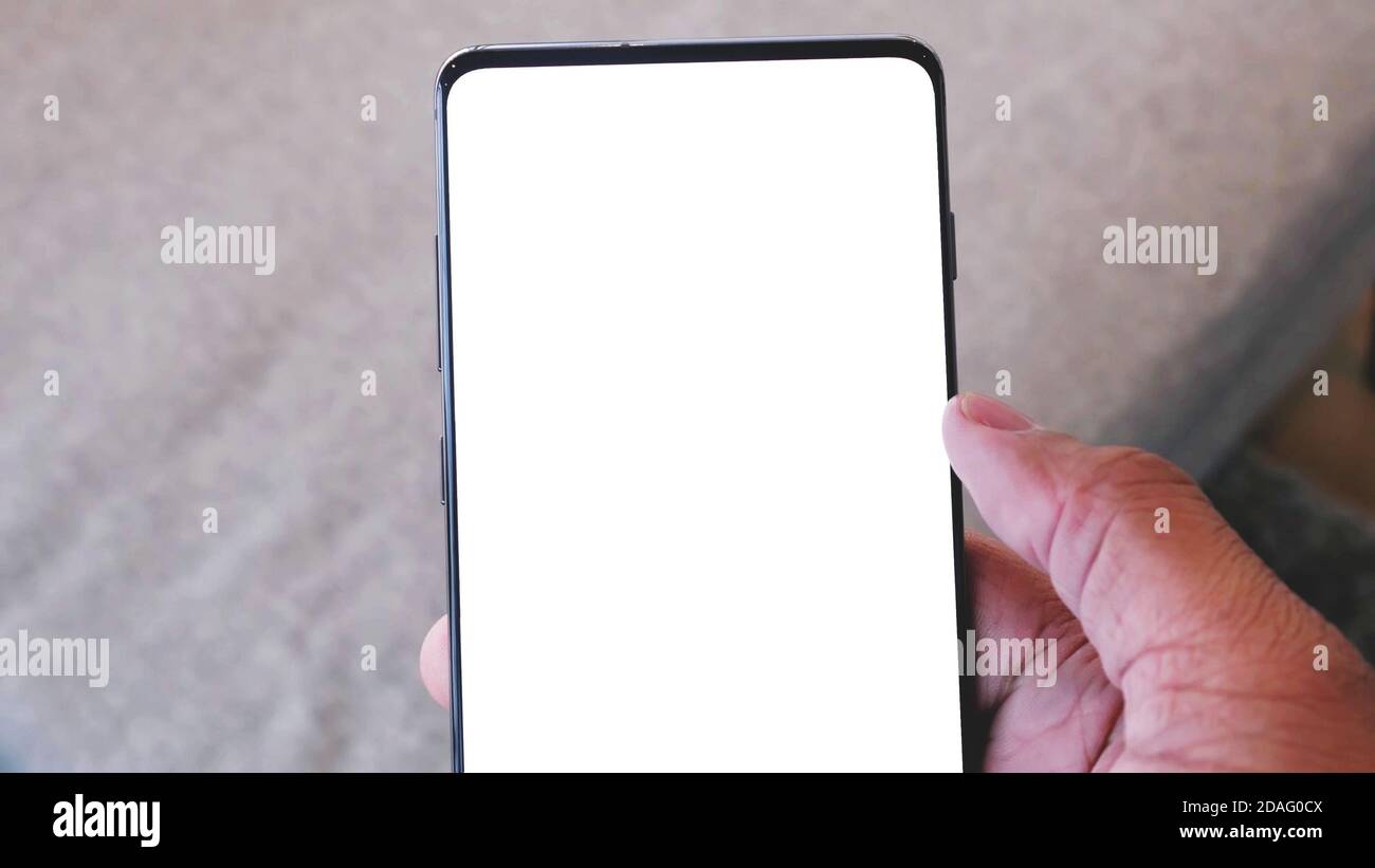 close up on a hand holding modern mobile phone with blank white screen. Stock Photo