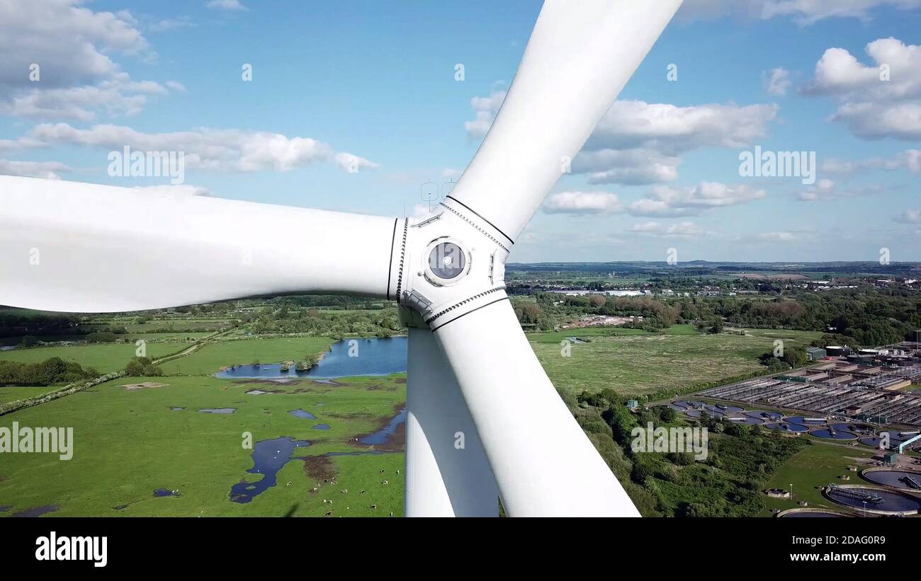 Close up view of wind Turbine blades with countryside industry area in background. Stock Photo