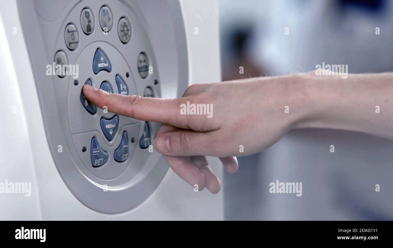 close up on finger press on settings buttons of MRI scanner. Stock Photo