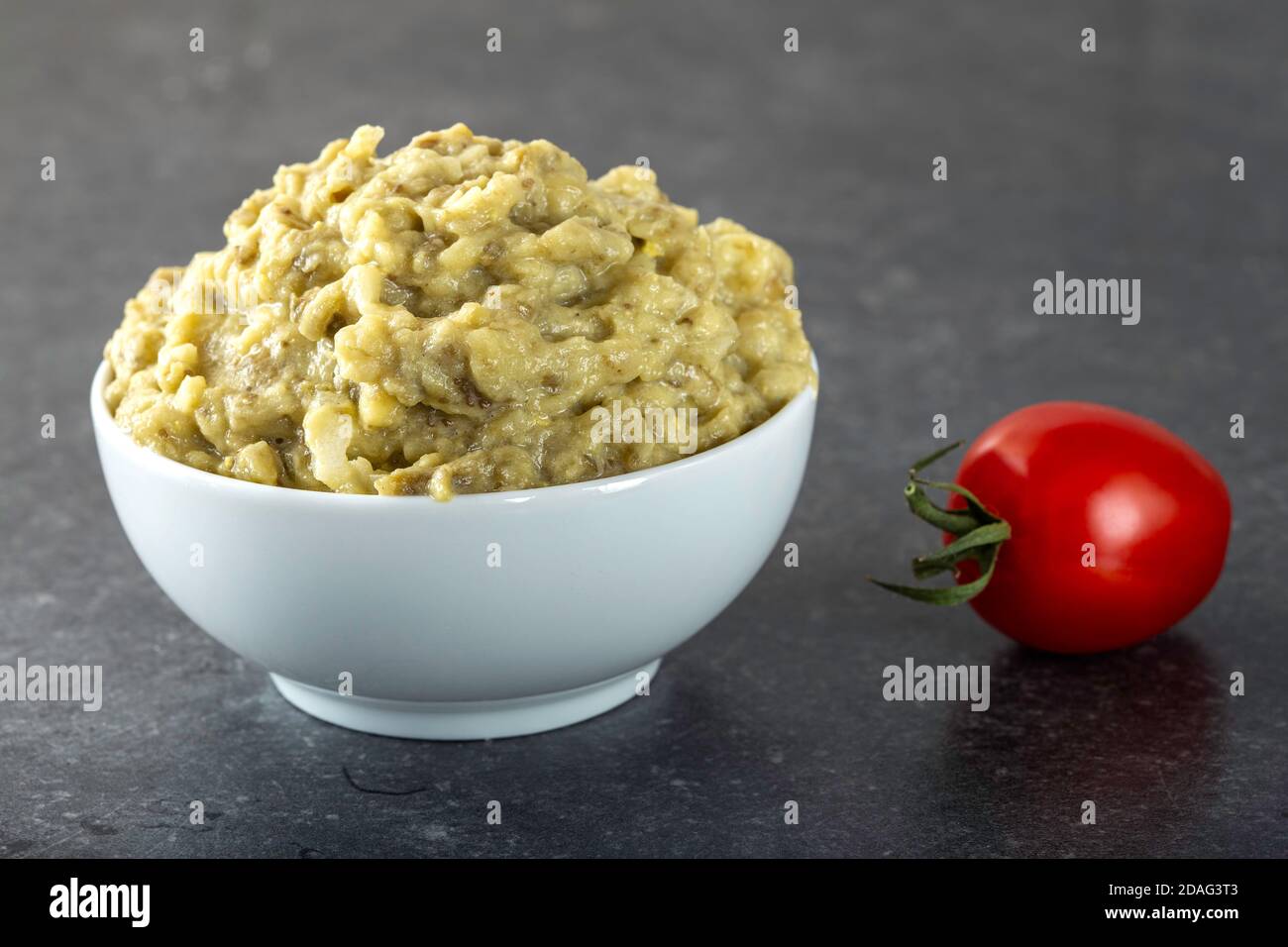 Eggplant salad with onion and mayonnaise in a white bowl Stock Photo