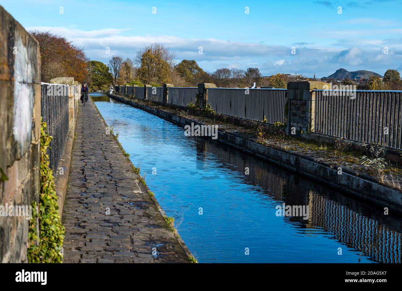 Man cycling on narrow path on Slateford Aqueduct, Union Canal, Edinburgh, Scotland, UK Stock Photo