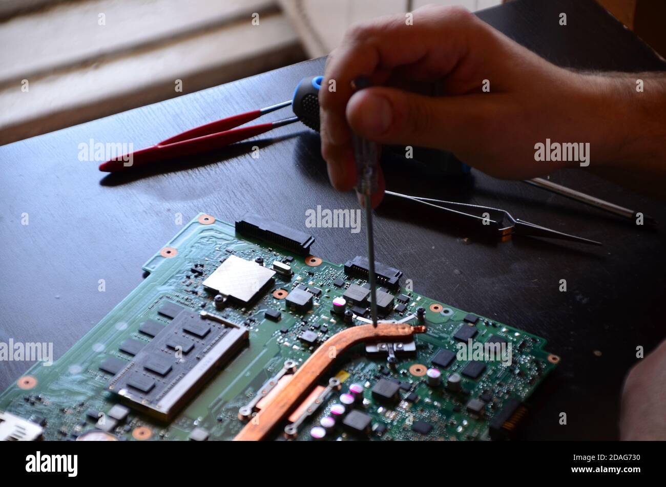 The man hand of the technician assembling inside of tablet by screwdriver in the lab. the