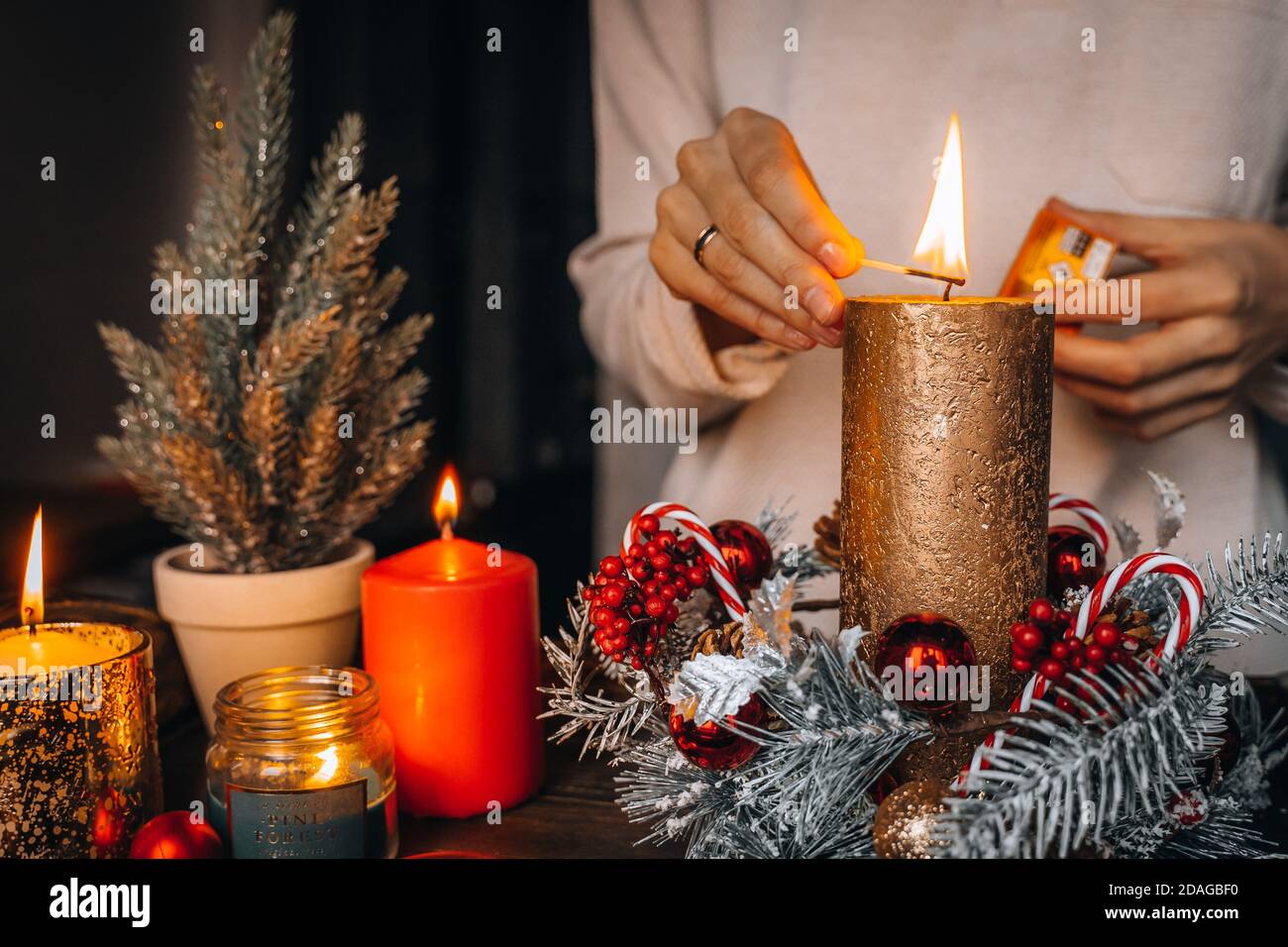 Close up of lighting first candle on Advent Wreath Celebrating Christmas or  new year holidays. warm lights, xmas tree winter home interior decorations  Stock Photo - Alamy