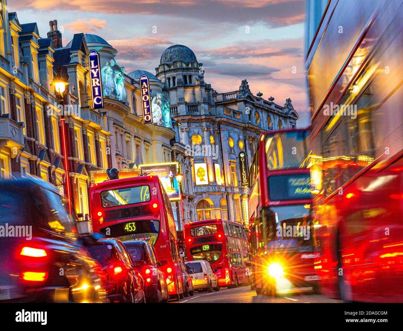 LONDON THEATRES SHAFTESBURY AVENUE NIGHT ULEZ LONDON TRAFFIC JAM SUNSET Theatreland traffic pollution blurred busy with red buses and taxis in Shaftesbury Avenue with Lyric Apollo & Gielgud Theatres featured West End London UK Stock Photo