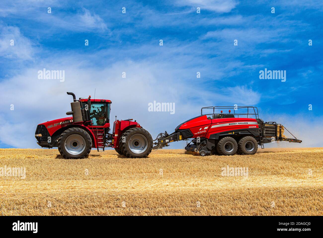 CaseIH 4WD wheeled tractor pulling a large rectangular baler to bale