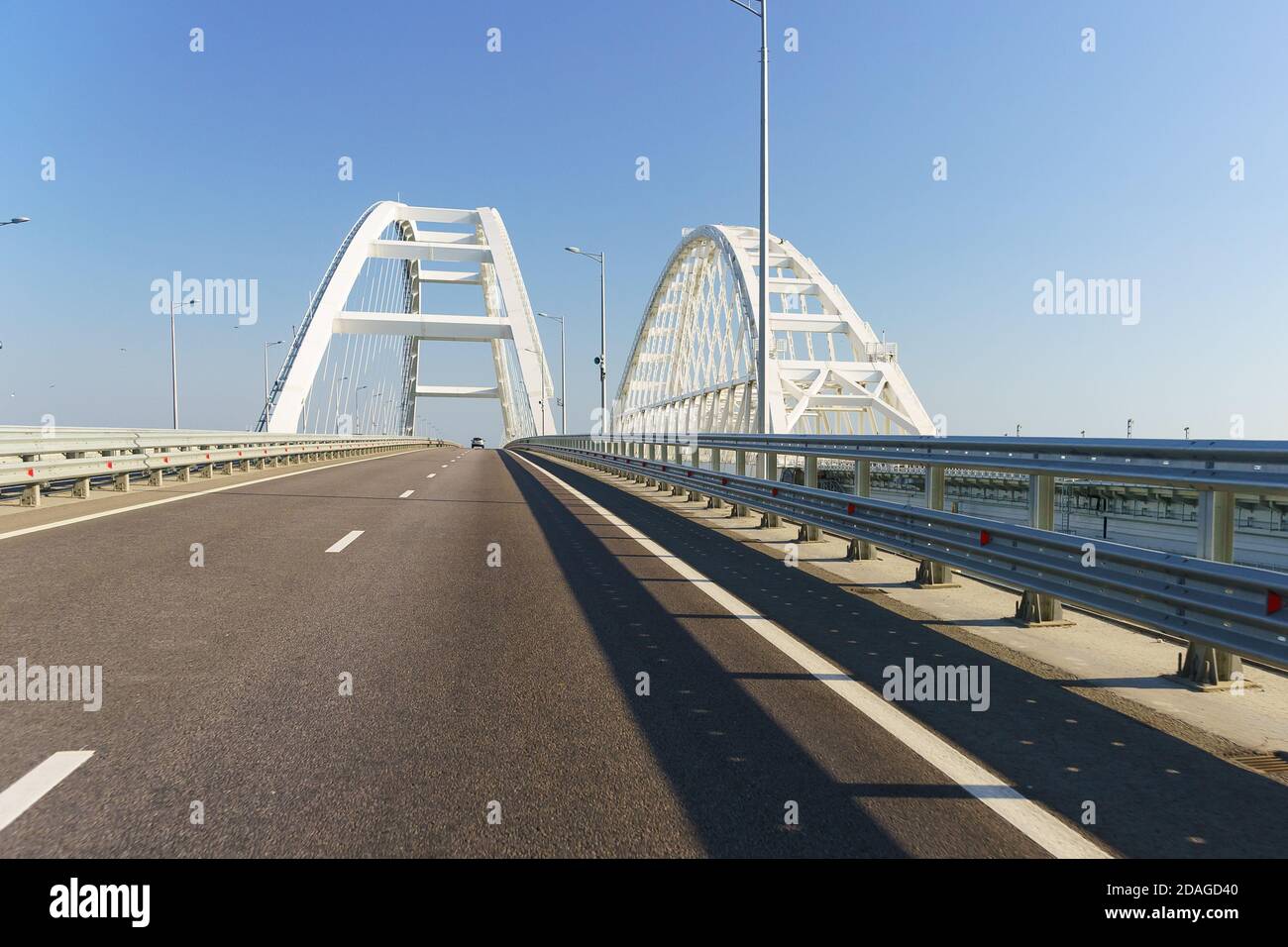 New asphalt road over the bridge over the Kerch Strait. White arches of unsupported span of automobile and railway roads Stock Photo