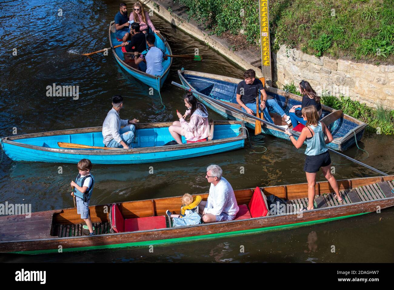 Boaters with rowing boats and a punt causing congestion on the River Cherwell by Oxford’s Magdalen Bridge. Stock Photo