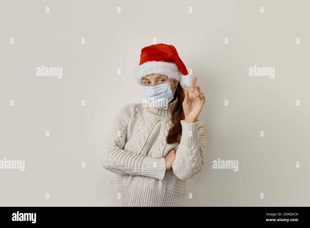 Woman wearing protection mask pointing with hand and finger up to the side Stock Photo