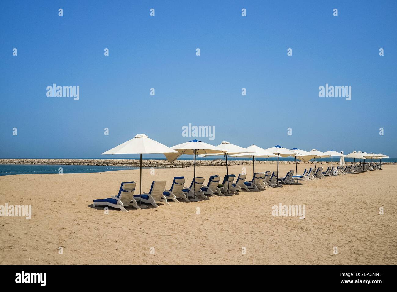 Beach umbrellas are in one line. Ras Al Khaima on the Persian Gulf. Stock Photo