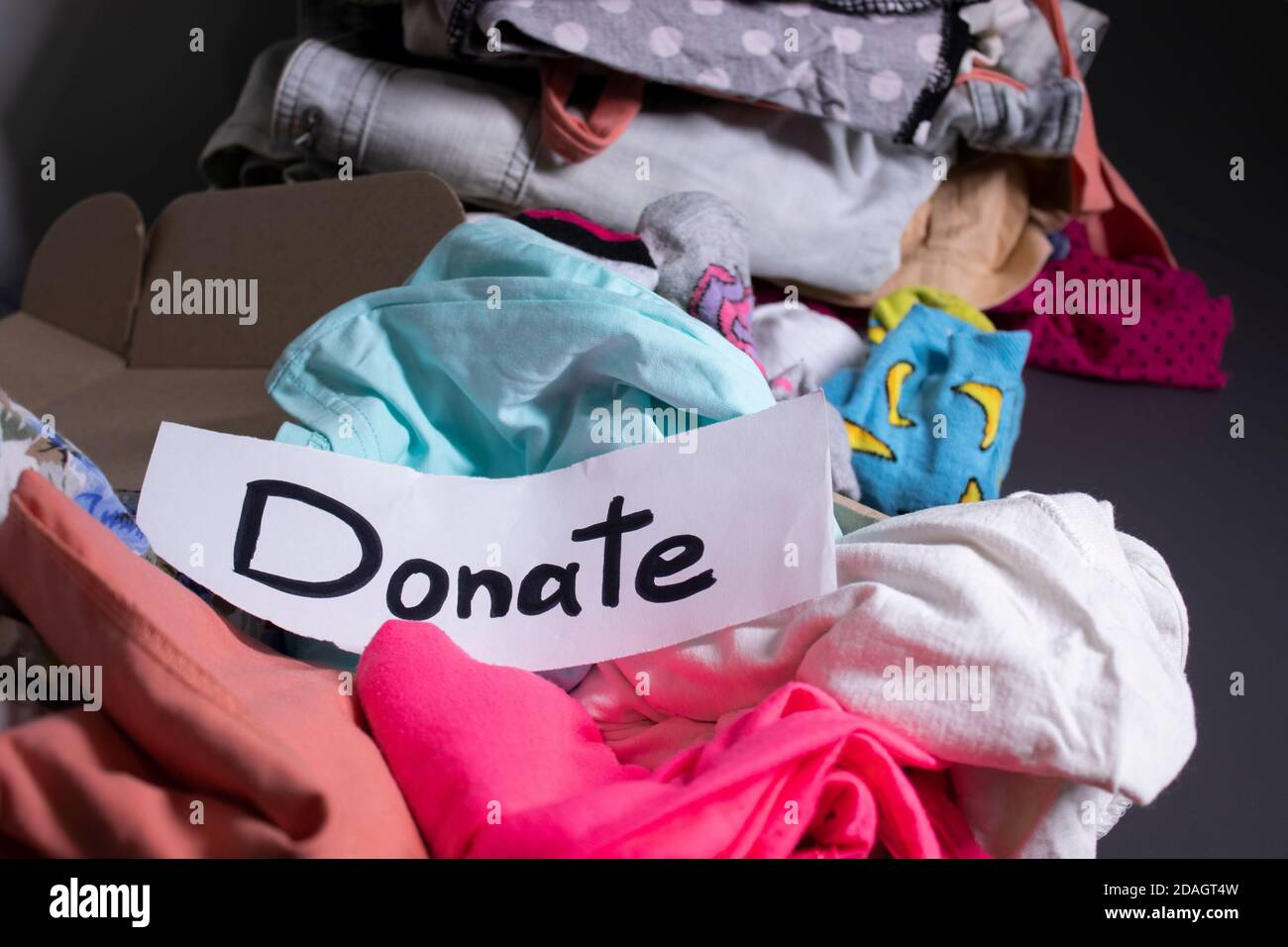 'Donate' sign handwritten with black letters. A box with clothes and a