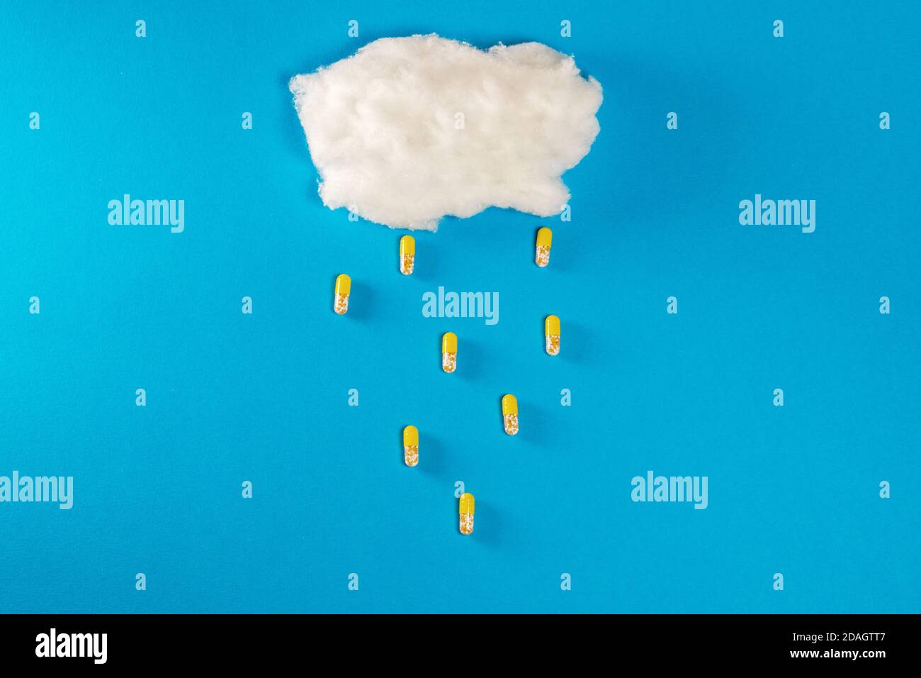Cloud made of foam on blue background with pills as rain drops Stock Photo