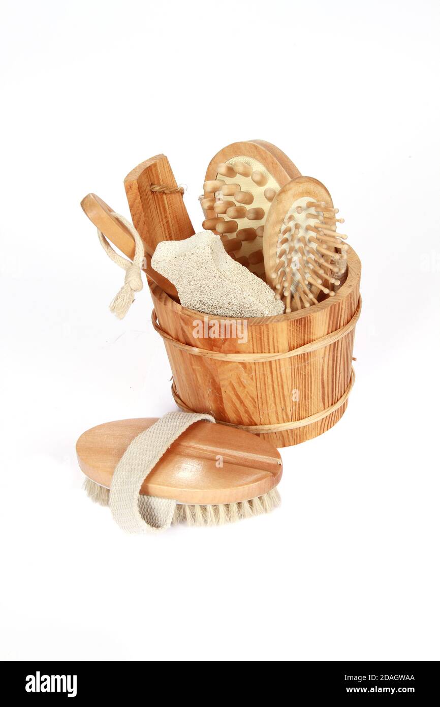 Vertical shot of wooden brushes and combs in a bucket isolated on a ...