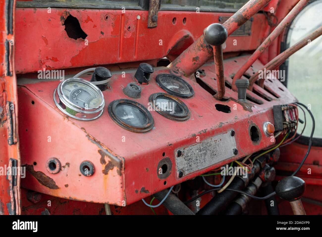 Closeup dashboard gages of old rusty red russian tractor during autumn harvest agriculture technology transportation vehicle Stock Photo