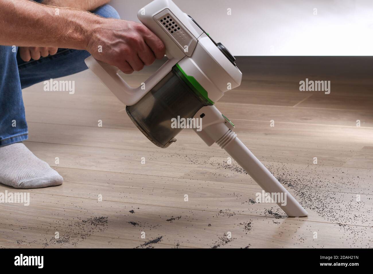 A man uses a bagless vertical cordless vacuum cleaner to clean the floor Stock Photo Alamy