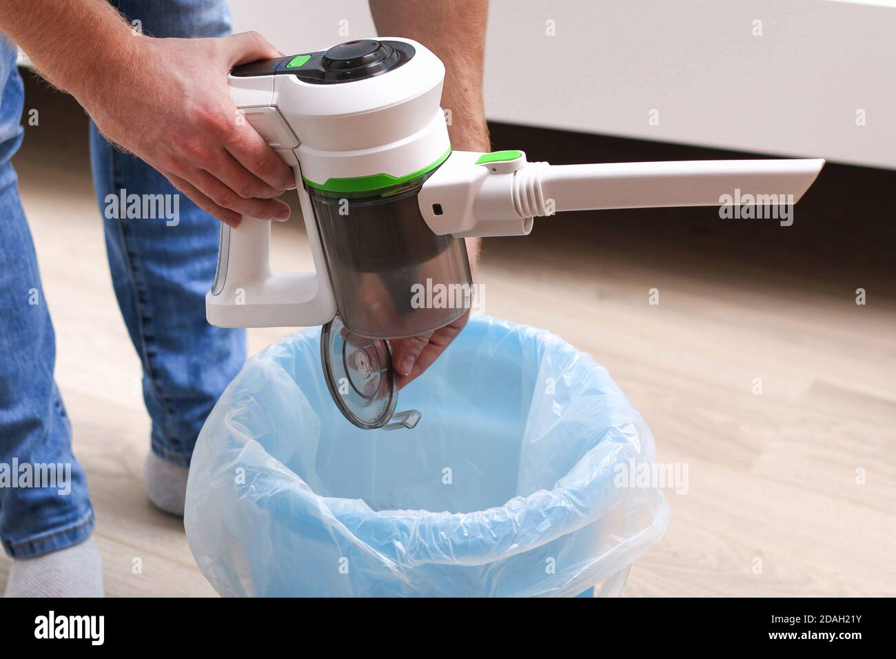 A man uses a bagless vertical cordless vacuum cleaner to clean the floor Stock Photo Alamy