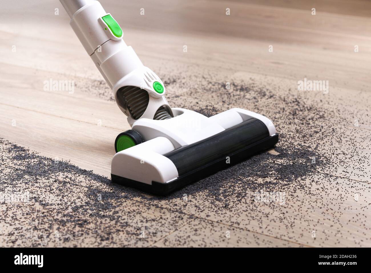 A man uses a bagless vertical cordless vacuum cleaner to clean the floor Stock Photo Alamy