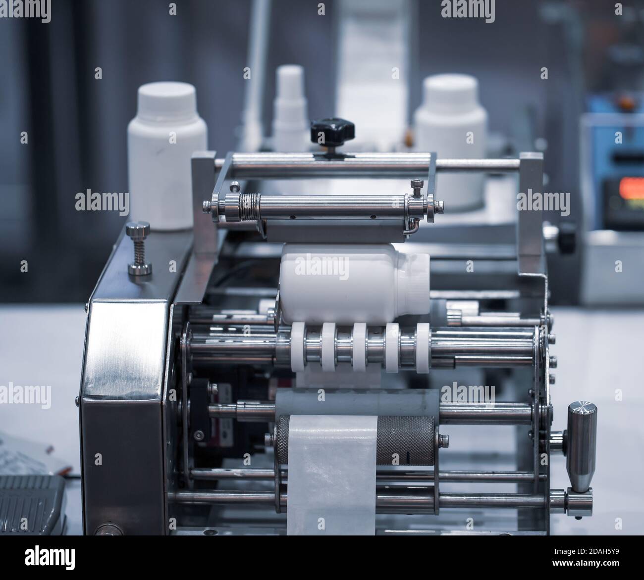 White bottle on labeling machine in pharmaceutical industrial Stock Photo