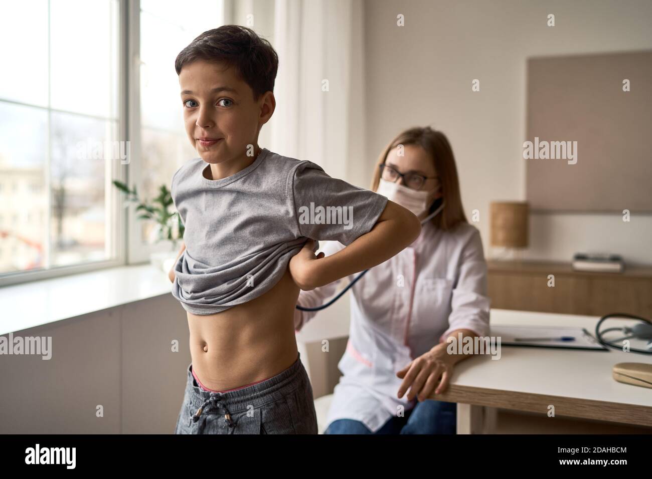 Cute boy with pleasure visiting pediatrician, scheduled check up of babys health, appointment with the family doctor, healthy lifestyle  Stock Photo