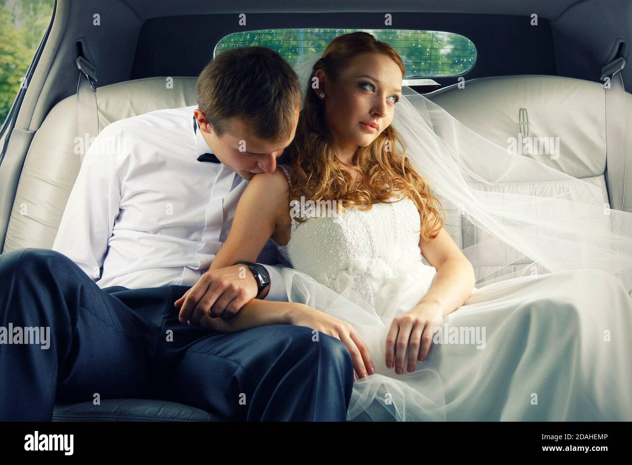 Bride and groom kissing in limousine on wedding-day Stock Photo - Alamy
