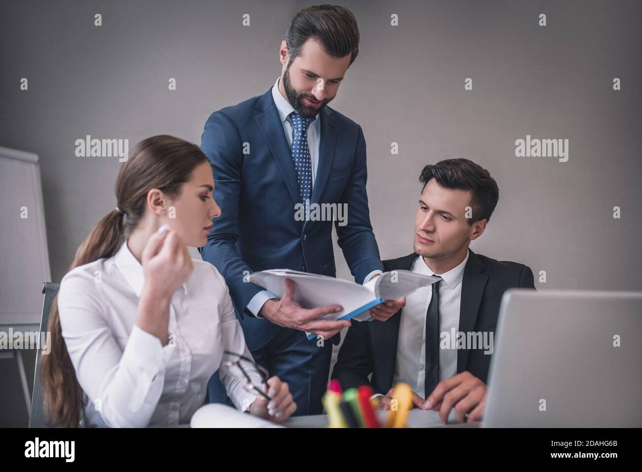 Three colleagues discussing the project in the office Stock Photo