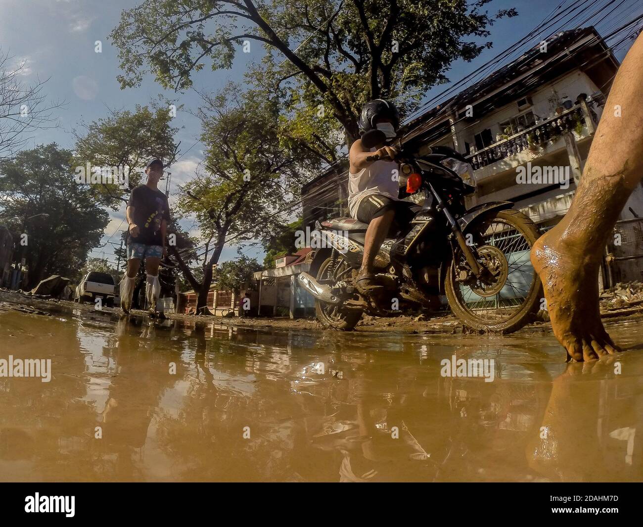 Manila, Philippines. 13th Nov, 2020. Residents walk on a muddy road after the flood brought by Typhoon Vamco in Manila, the Philippines, Nov. 13, 2020. The Philippine government said on Friday that Typhoon Vamco, which has caused devastating floods and landslides in the main island of Luzon, has killed at least 14 people, officials said. Credit: Rouelle Umali/Xinhua/Alamy Live News Stock Photo