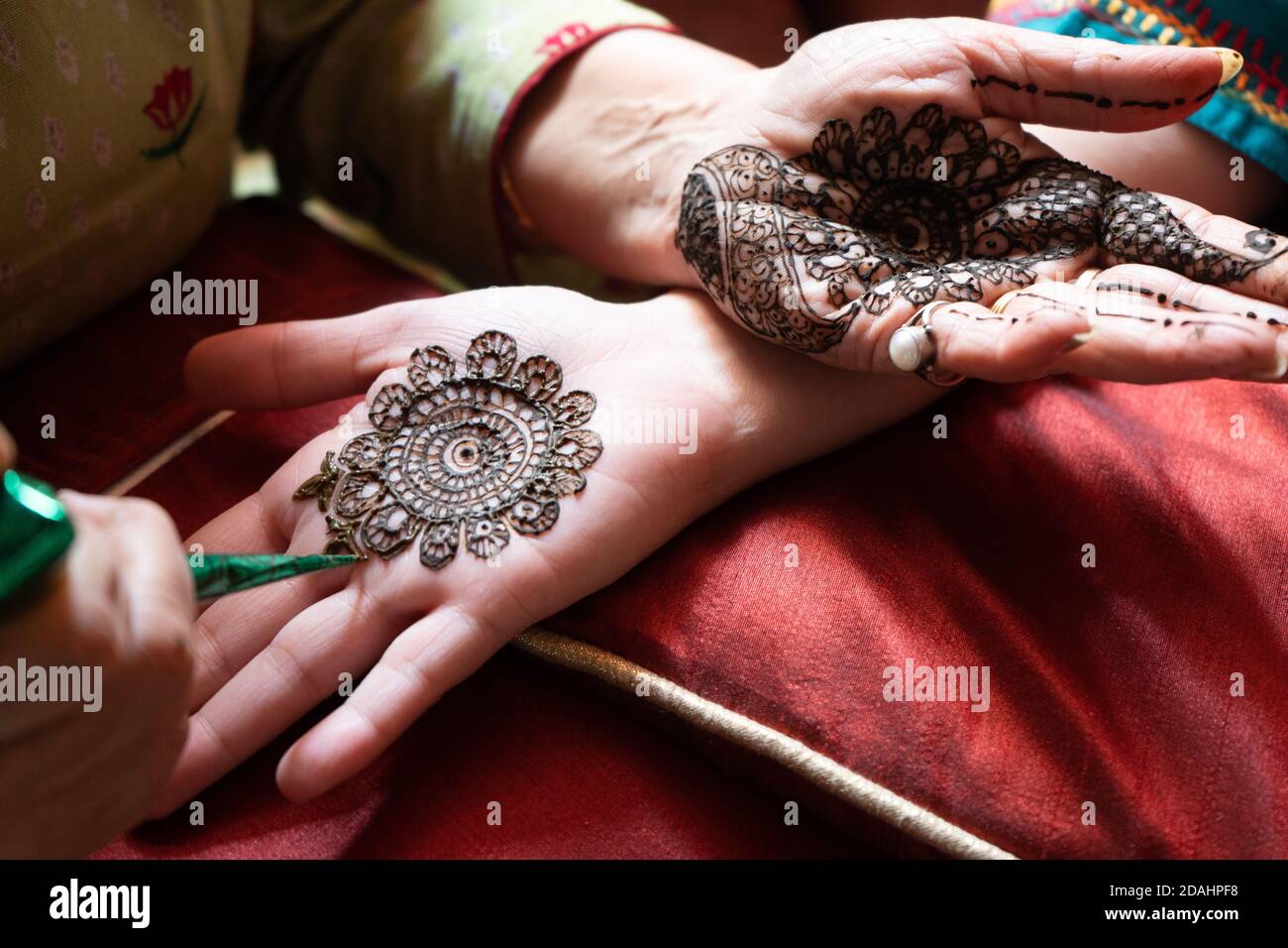 top down video of a woman copying the mehndi henna tattoo from one hand to the other in preparation of the hindu festival of teej karwachauth diwali 2DAHPF8