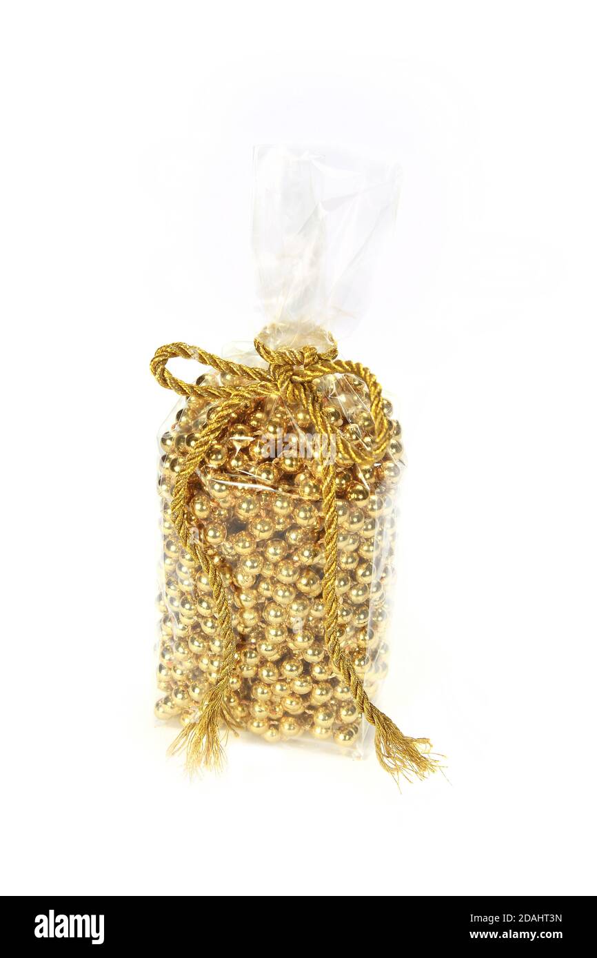 Closeup of golden pearl beaded chain in their pack isolated on a white background Stock Photo