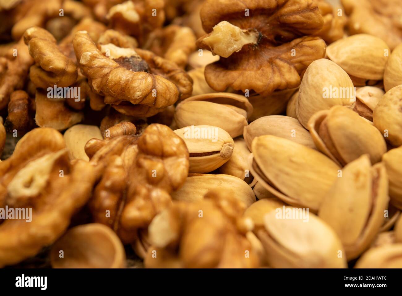 Pistachios and walnuts lie on the sacking. Close up Stock Photo