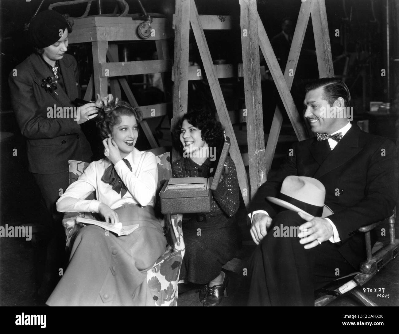 JEANETTE MacDONALD having her hair fixed and CLARK GABLE on set candid during filming of SAN FRANCISCO 1936 director W.S. VAN DYKE story Robert E. Hopkins screenplay Anita Loos Metro Goldwyn Mayer Stock Photo