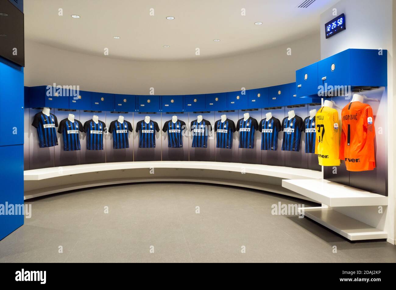 Seats for a team of football players with a blue uniform on top in the  locker