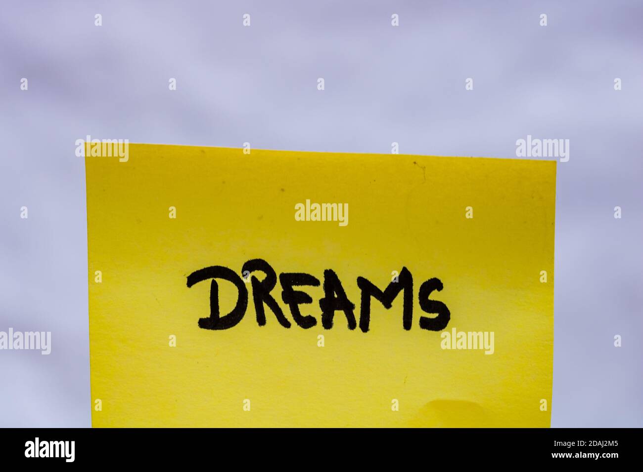 Dreams handwriting text close up isolated on yellow paper with copy ...