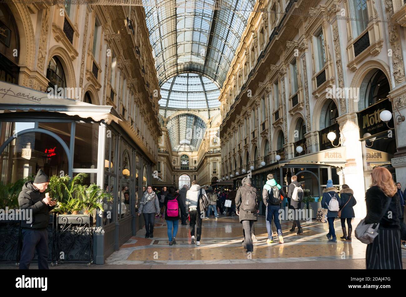 People walk through the Vittorio Emanuele II Gallery - a unique indoor shopping gallery in the center of Milan, built in 1865-1877. Italy. Stock Photo
