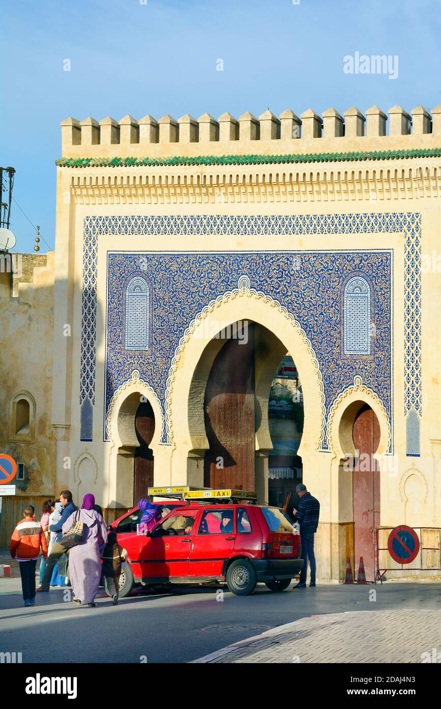 Fes, Morocco - November 20, 2014: Unidentified people and car named Petit Taxi in front of Bab Boujeloud, entrance to Unesco world heritage site souk Stock Photo