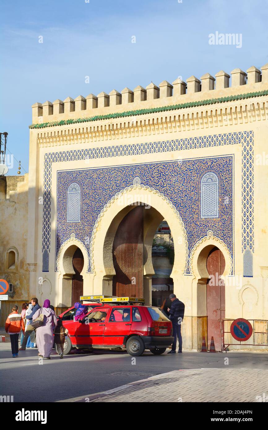 Fes, Morocco - November 20, 2014: Unidentified people and car named Petit Taxi in front of Bab Boujeloud, entrance to Unesco world heritage site souk Stock Photo