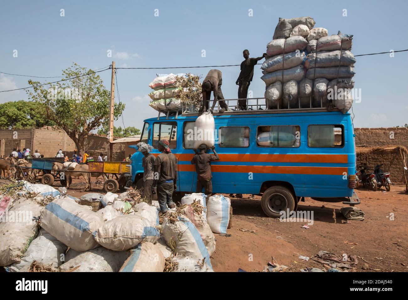 Selingue, Mali, 25th April 2015; On market day in Selingue buses are overloaded with sacks of charcoal for transportation to Bamako. Stock Photo