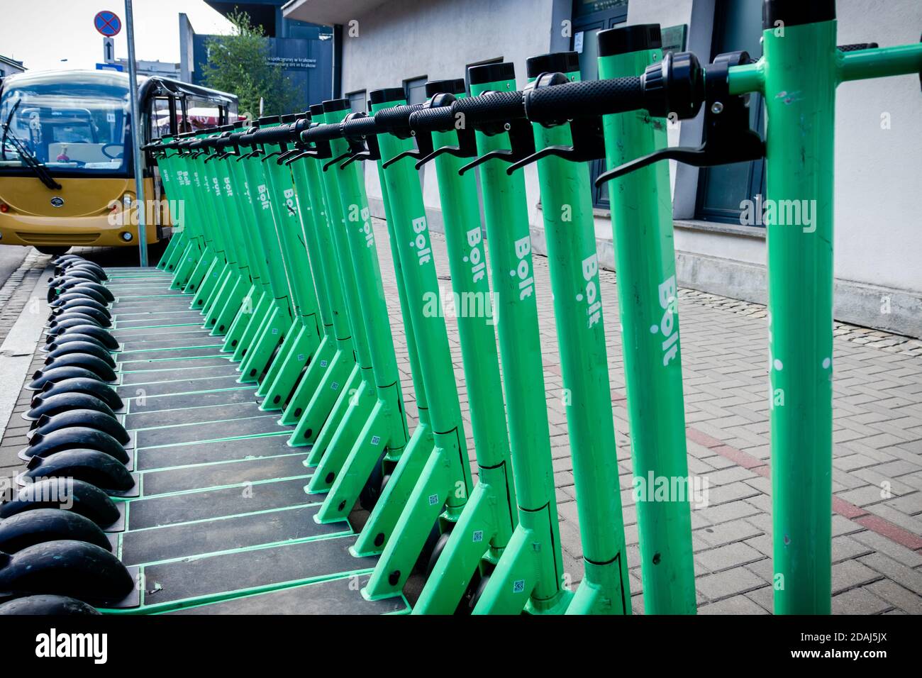 Row of green scooter decks and handlebars in Krakow, Poland on a summer day. Stock Photo