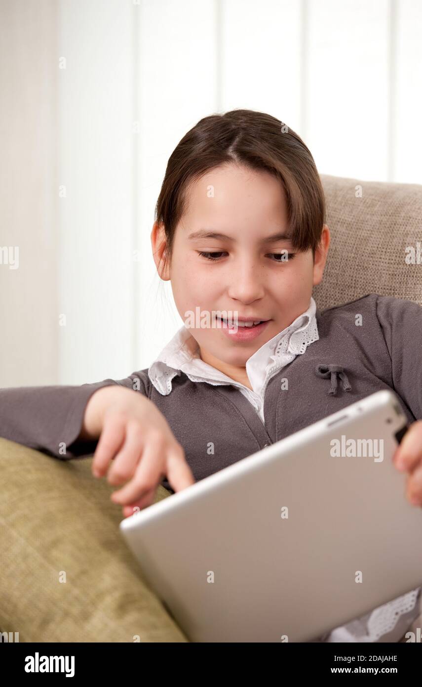 young girl on sofa with touch tablet computer Stock Photo - Alamy